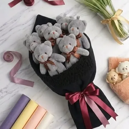 Siyah sargı içinde peluş ayıcıklardan hazırlanmış buket, bordo kurdele