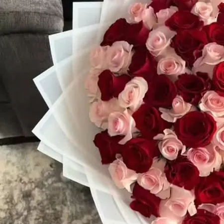 Kırmızı ve pembe güllerden hazırlanmış beyaz sargılı buket